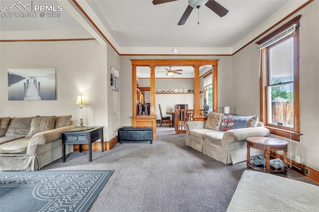 Image 7 of 49: Carpeted living area with baseboards and a ceiling fan