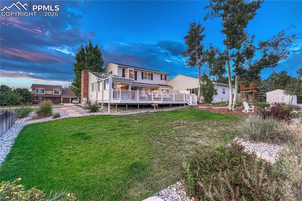 Image 1 of 44: Expansive backyard with a manicured lawn, a multi-level deck, mature trees,