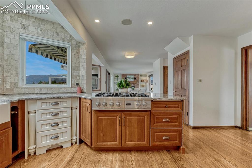 Image 12 of 44: Gourmet kitchen with professional-grade gas range, granite countertops, woo