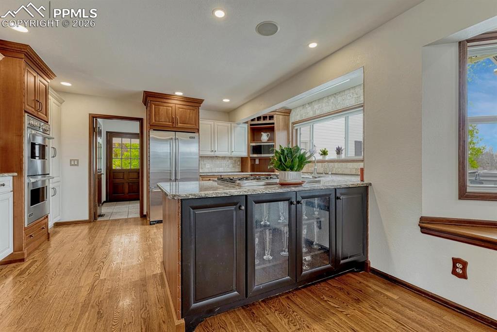 Image 14 of 44: Gourmet kitchen featuring a granite-topped island with integrated beverage 