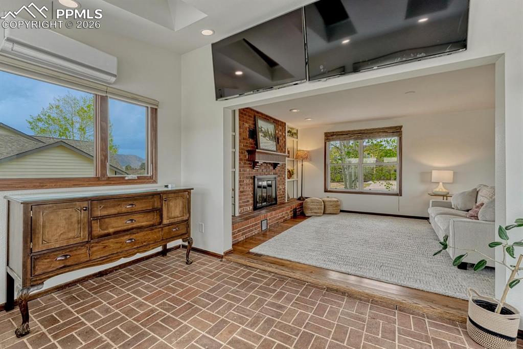 Image 16 of 44: Brick-patterned flooring with a contrasting raised wood-finish floor