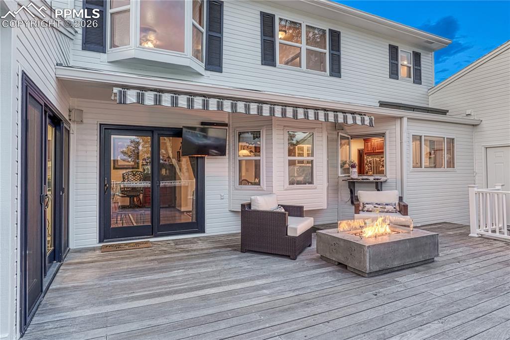 Image 18 of 44: Expansive wood-finish deck featuring a built-in fire pit
