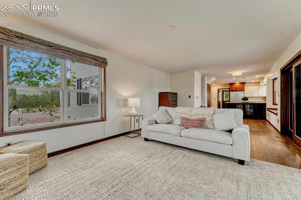 Image 19 of 44: Bright living space featuring a large window with wood trim, textured rolle