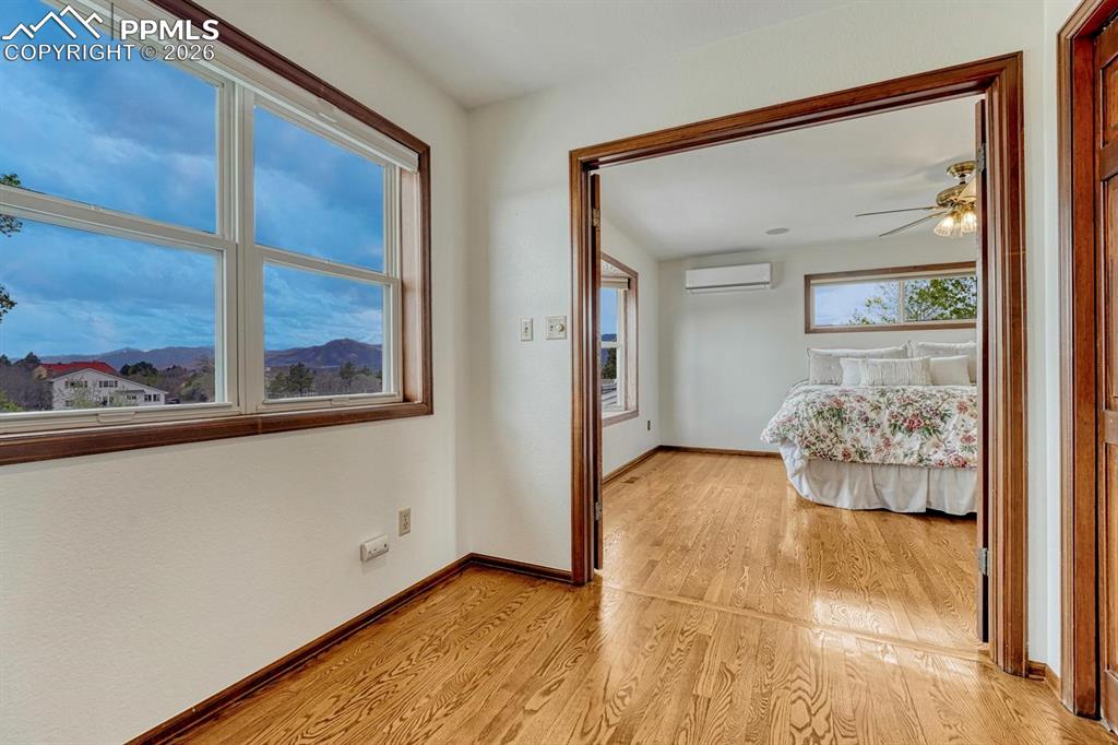 Image 23 of 44: Hardwood flooring extending into an adjacent room, featuring white walls, w