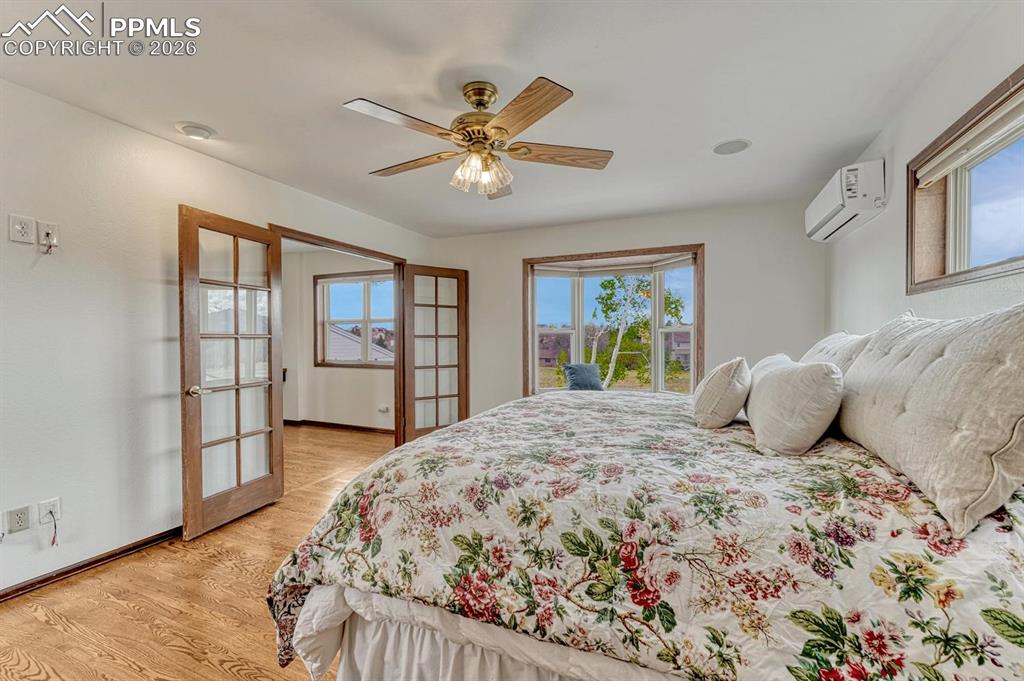 Image 28 of 44: Bedroom featuring light wood-finish flooring, a ceiling fan with light fixt