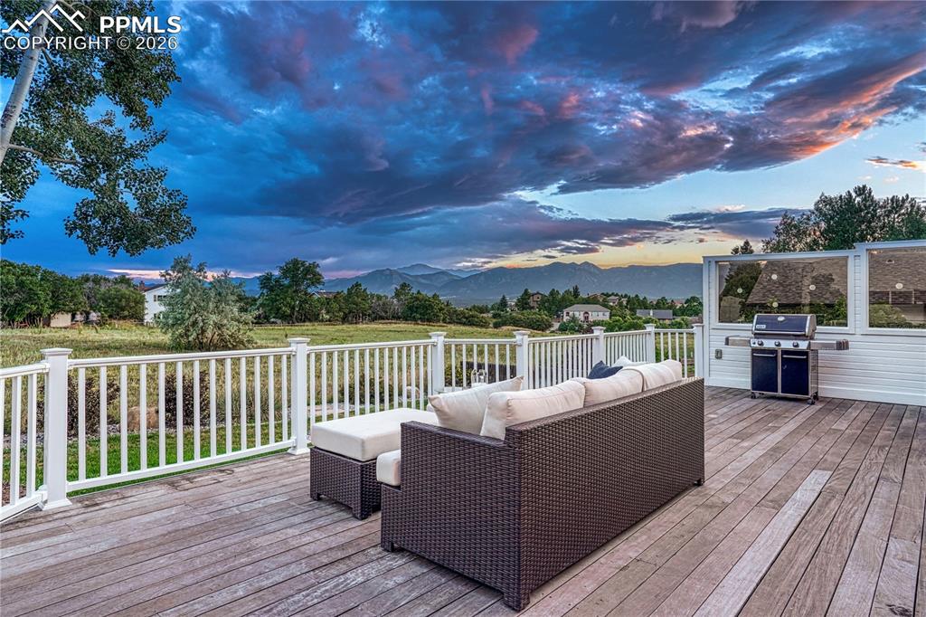 Image 3 of 44: Expansive outdoor deck featuring wood-finish flooring, white railing, and a