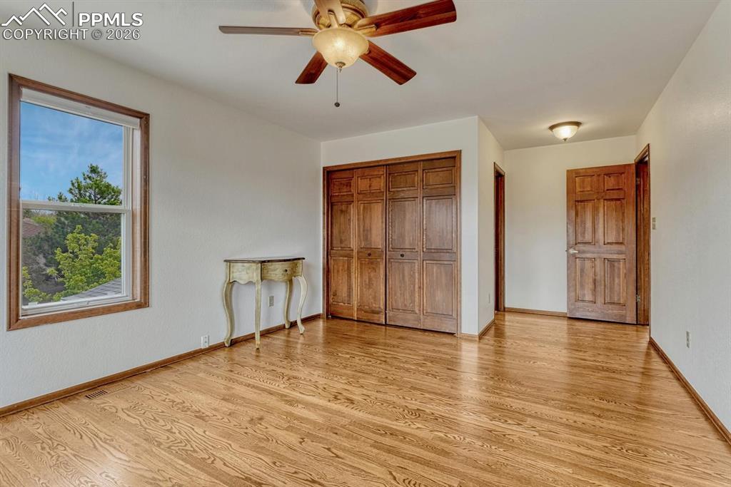 Image 35 of 44: Spacious room featuring wood-finish flooring, a ceiling fan with integrated