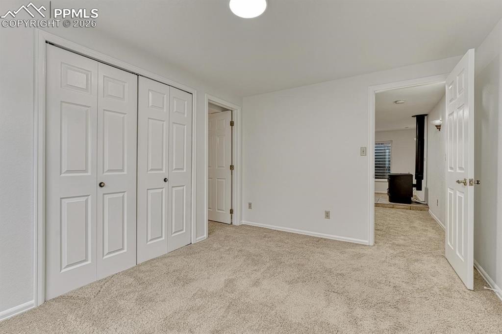 Image 39 of 44: Wall-to-wall carpeting in a neutral tone, white walls, and a pair of two-pa