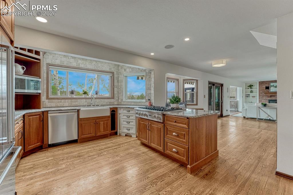Image 4 of 44: Open-concept kitchen featuring wood-finish flooring, a central island with 