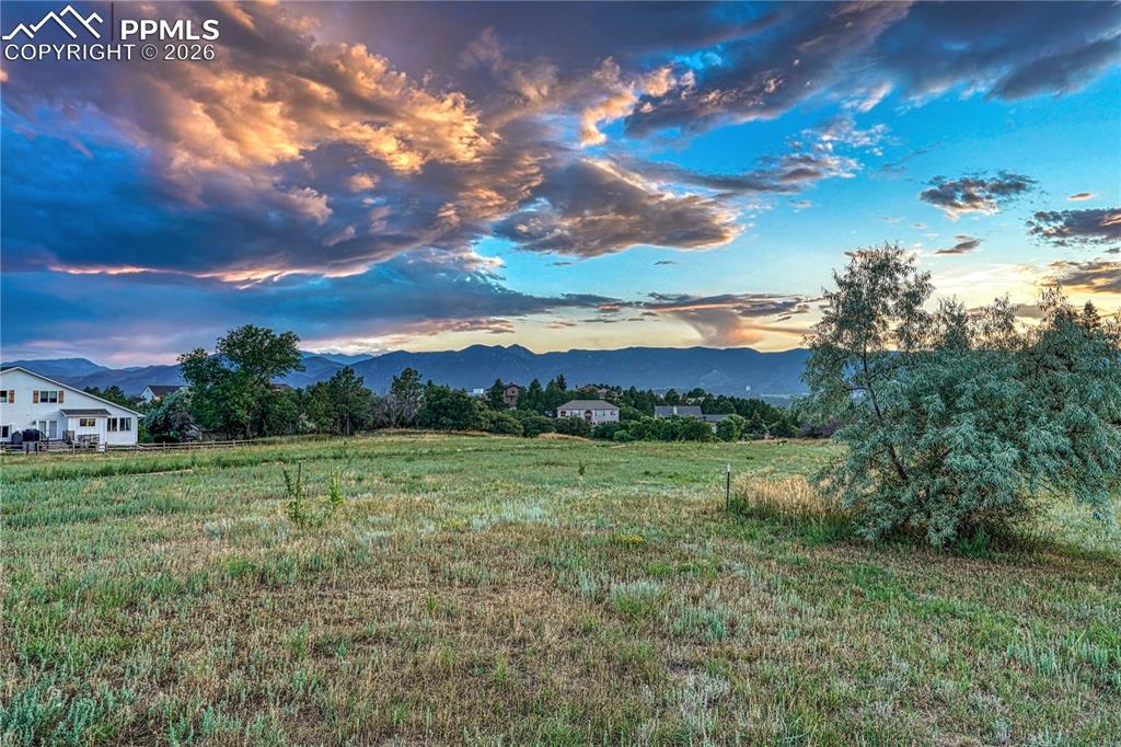 Image 41 of 44: Expansive grassy lot featuring distant mountain ranges and trees