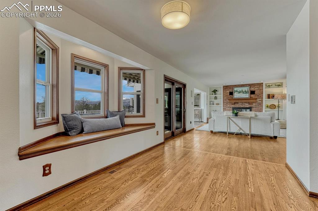 Image 6 of 44: Hardwood flooring extending into an open-concept living space with a built-