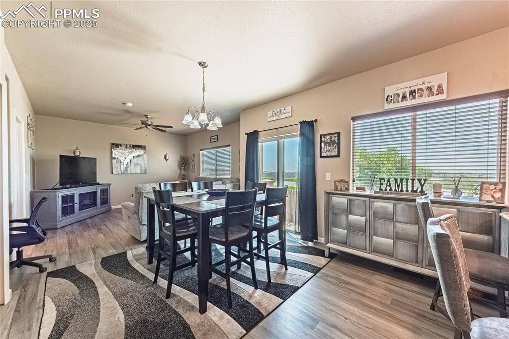 Image 11 of 33: Dining room with a chandelier, wood finished floors, and ceiling fan