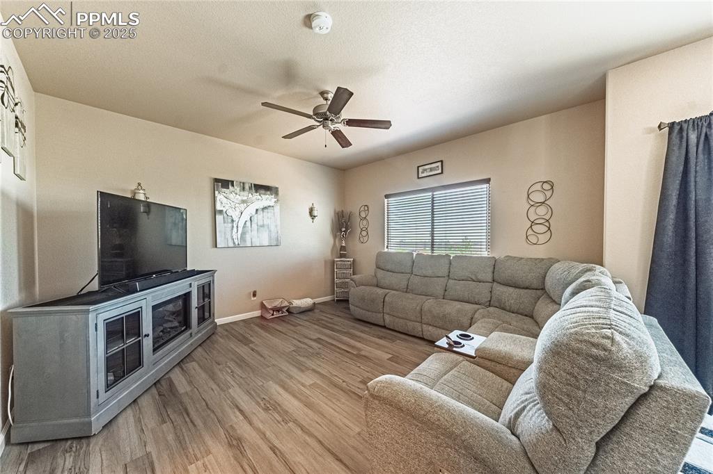 Image 13 of 33: Living area with wood finished floors and a ceiling fan