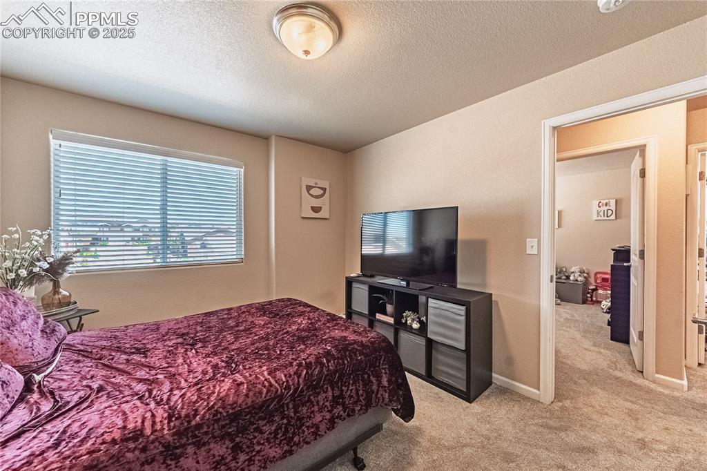 Image 19 of 33: Bedroom with light carpet and a textured ceiling