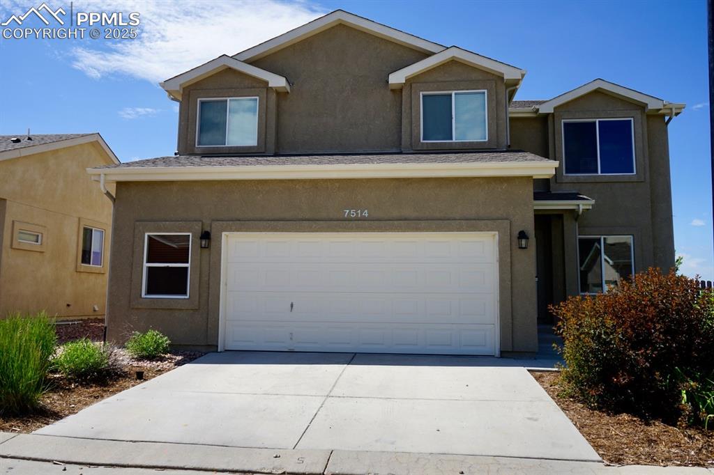 Image 2 of 33: View of front of house featuring stucco siding, a garage, and concrete driv
