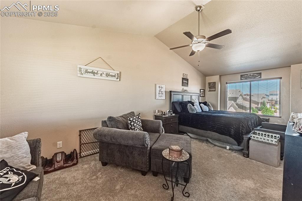 Image 28 of 33: Bedroom with carpet floors, vaulted ceiling, and ceiling fan