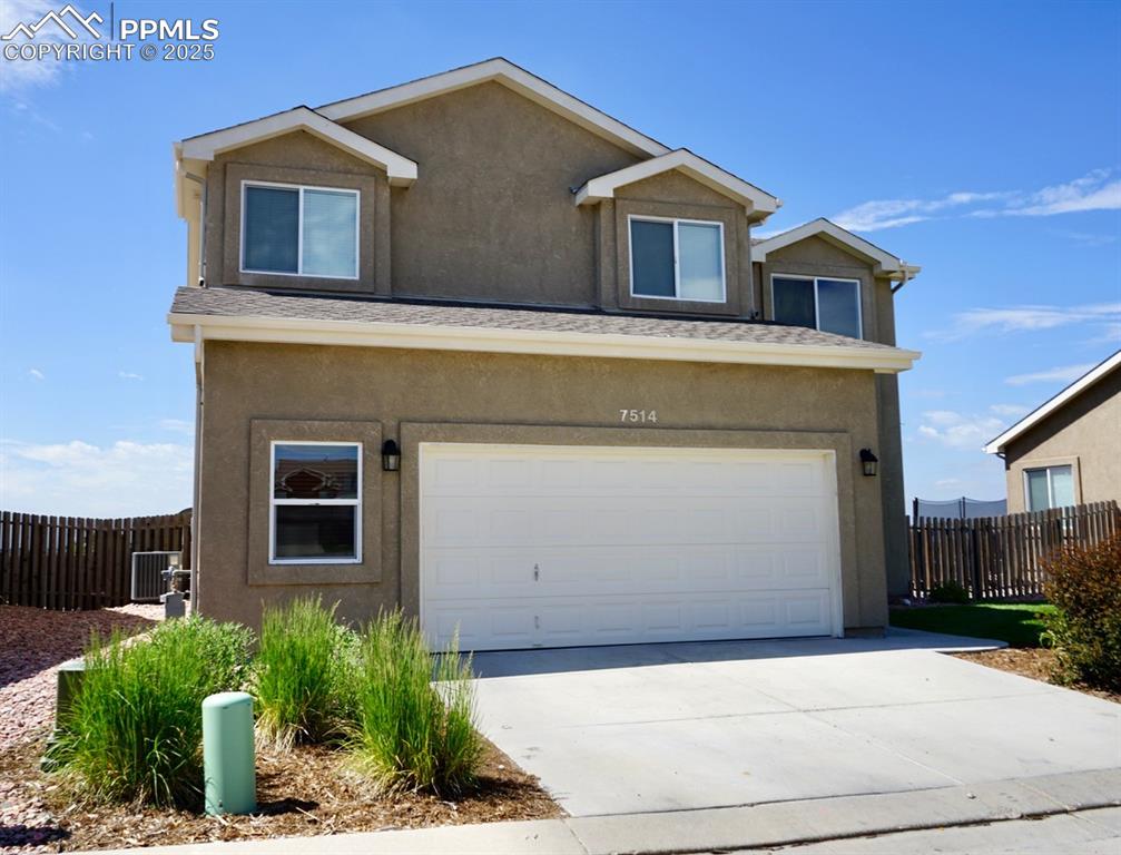 Image 3 of 33: View of front of home featuring stucco siding, an attached garage, and driv