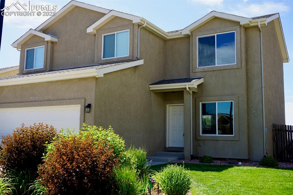 Image 4 of 33: View of front of home featuring stucco siding and an attached garage