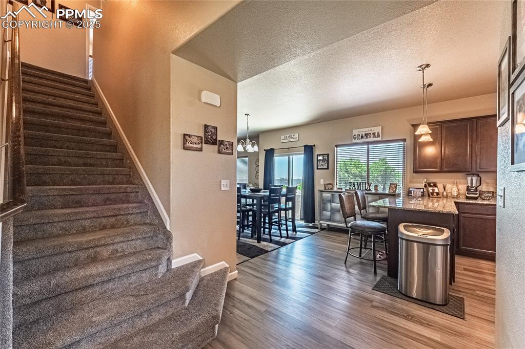 Image 7 of 33: Entry with staircase to upstairs or into the kitchen.