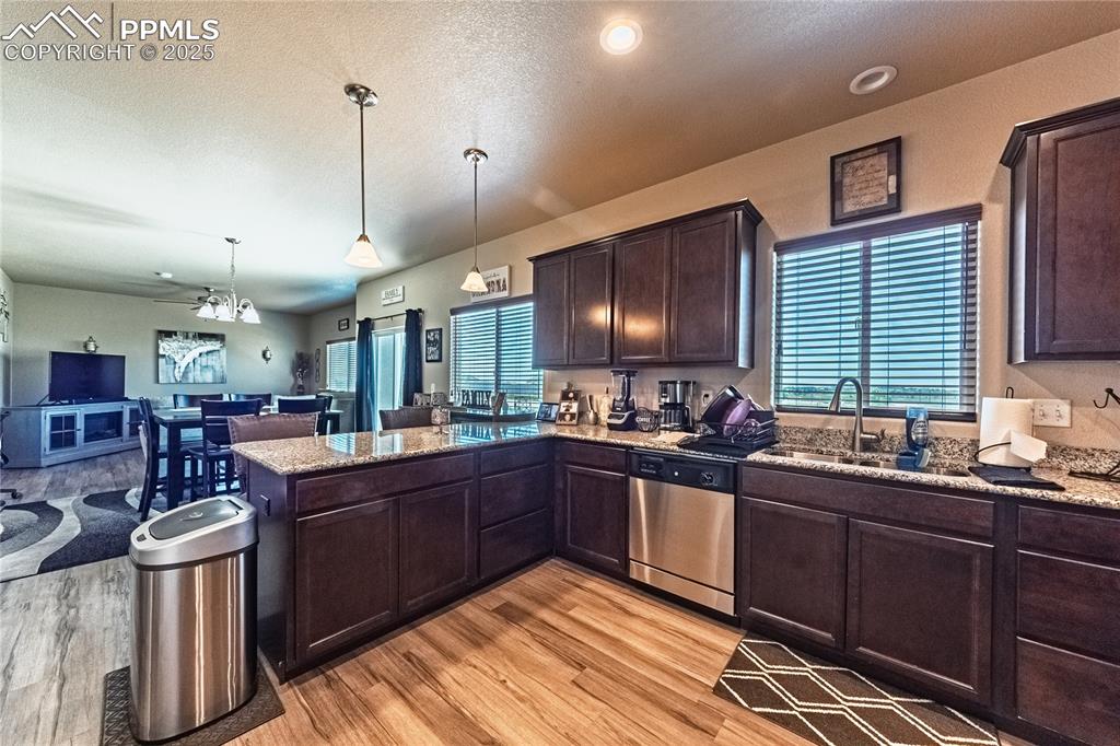 Image 9 of 33: Kitchen featuring stainless steel dishwasher, light wood-type flooring, ope