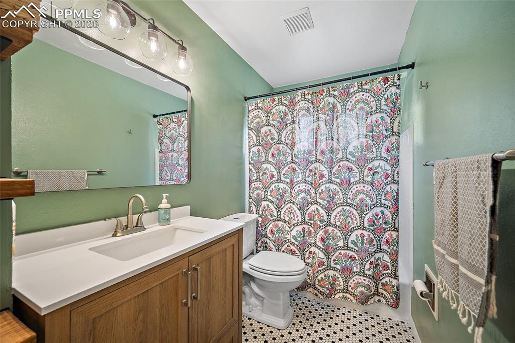 Image 16 of 49: updated bathroom with new tile flooring and a new vanity