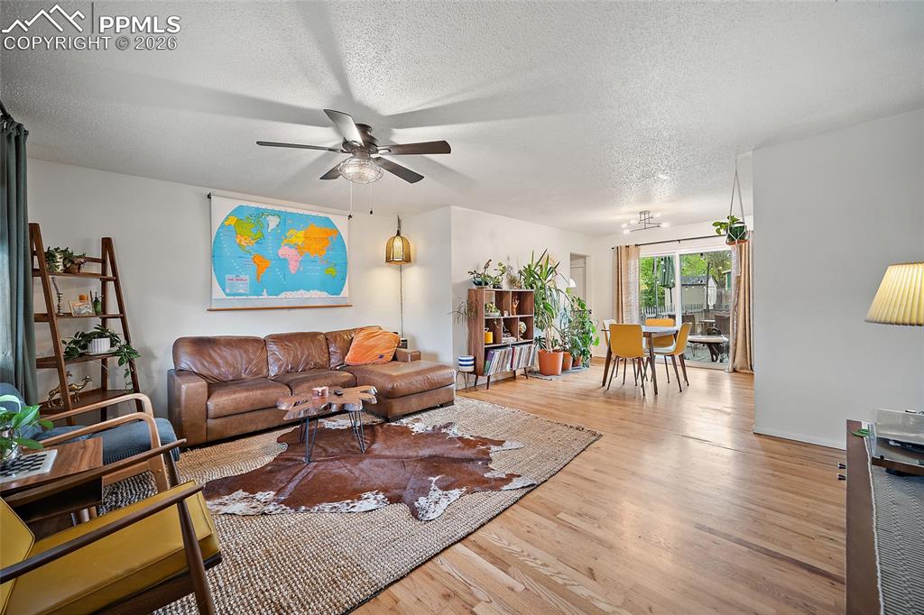 Image 4 of 49: living room with real wood floors and a ceiling fan