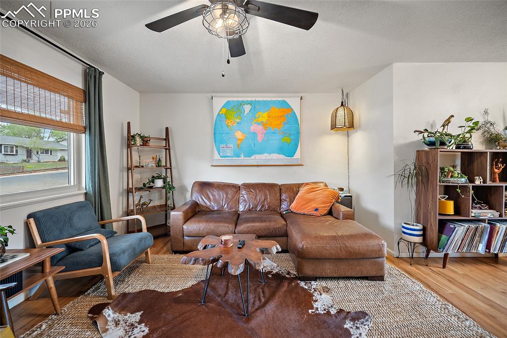 Image 5 of 49: living room with real wood floors and a ceiling fan