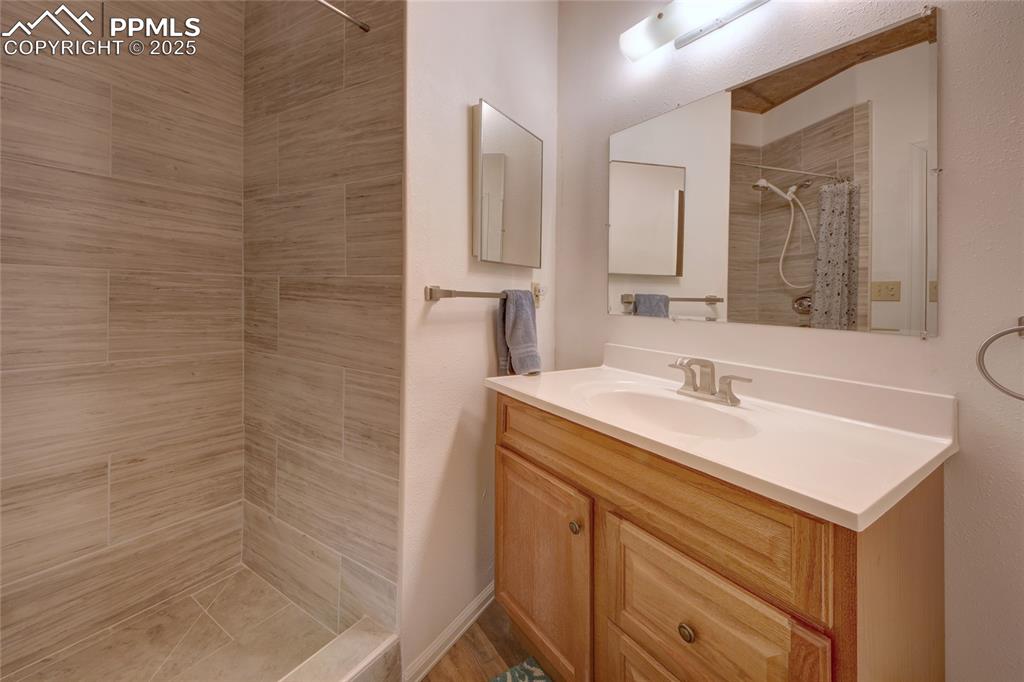 Image 13 of 33: Main Bathroom featuring vanity and tiled shower
