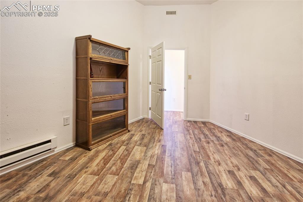 Image 18 of 33: Unfurnished office off of Garage w/ baseboard heating, baseboards, wood fin