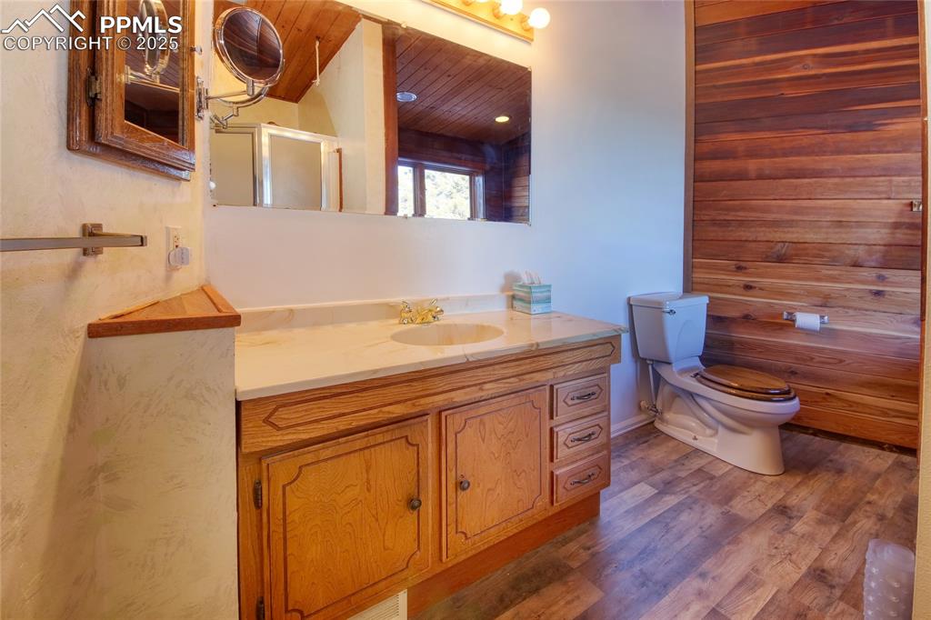 Image 19 of 33: Bathroom featuring wood finished floors, vanity, a shower with shower door,