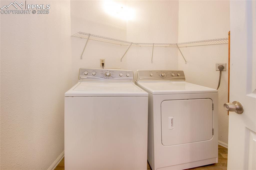 Image 22 of 33: Laundry room featuring washing machine and dryer and laundry area