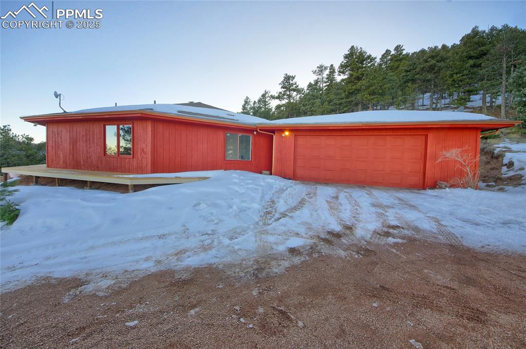 Image 3 of 33: View of front of house with roof mounted solar panels and a garage
