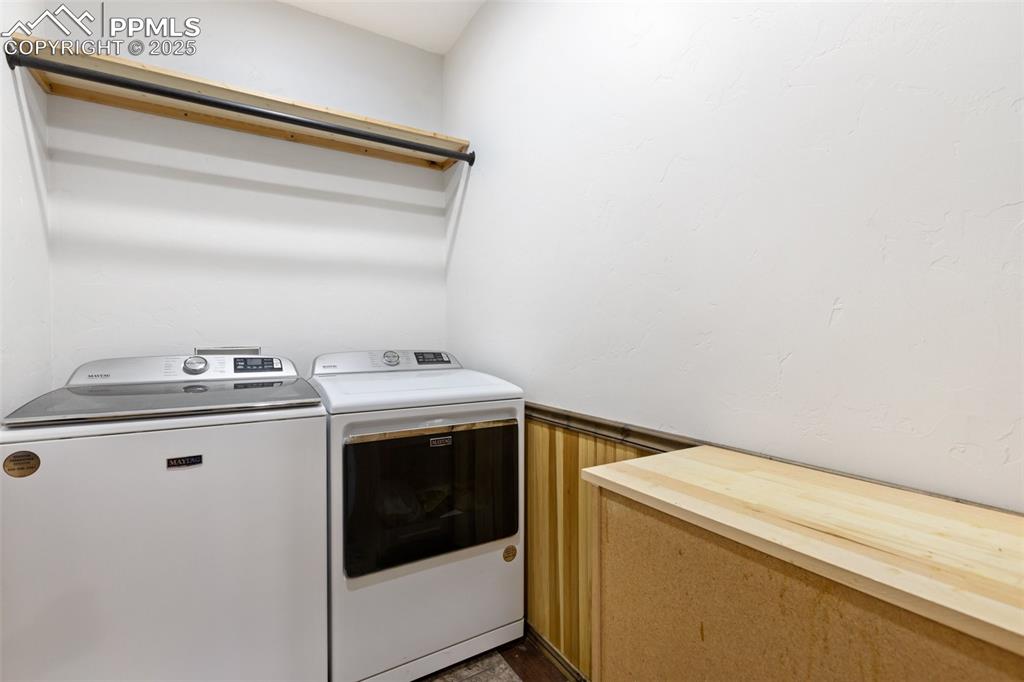 Image 34 of 46: Laundry area featuring washing machine and dryer and a wainscoted wall