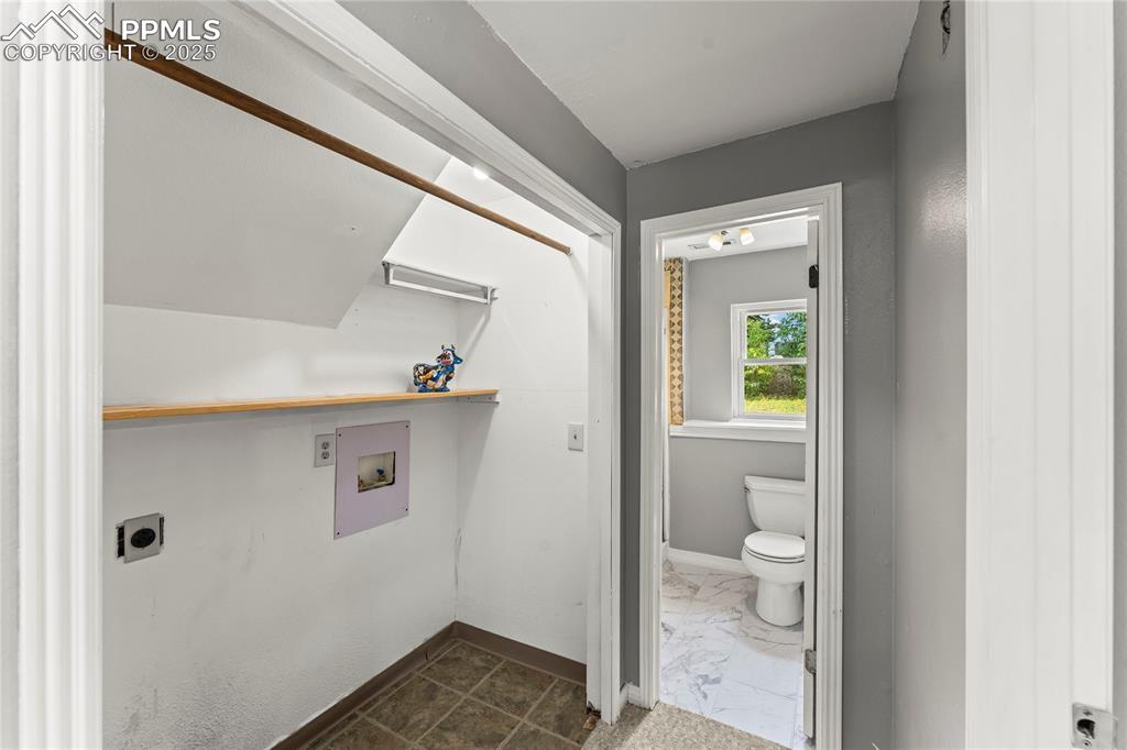 Image 10 of 21: Washroom with hookup for an electric dryer, washer hookup, and dark marble 