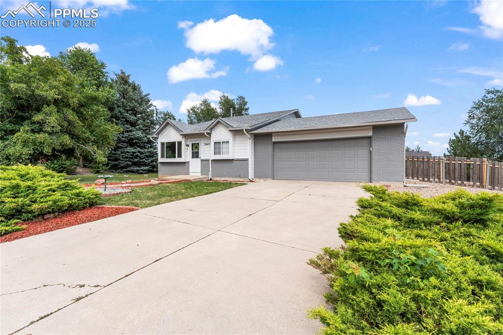 Image 20 of 21: Ranch-style house featuring an attached garage, brick siding, concrete driv
