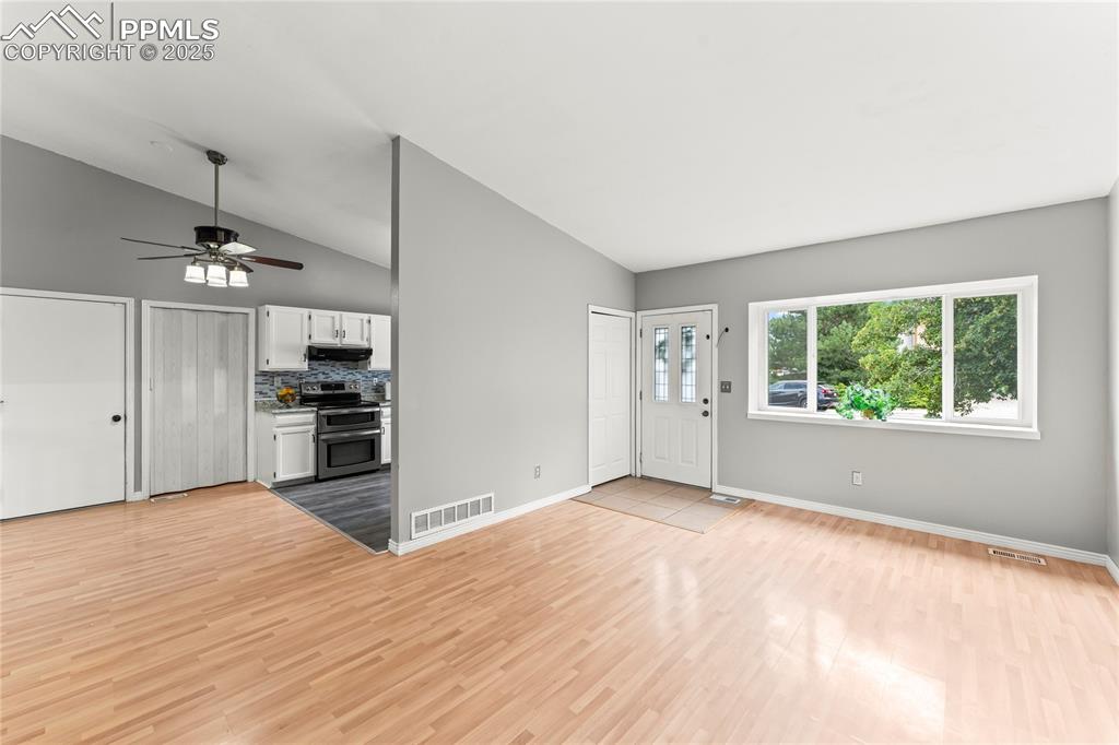 Image 3 of 21: Unfurnished living room with lofted ceiling, light wood-type flooring, and 