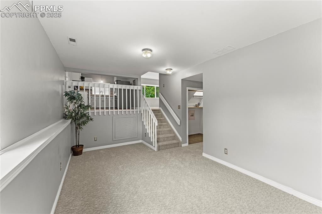 Image 9 of 21: Empty room with carpet floors and baseboards