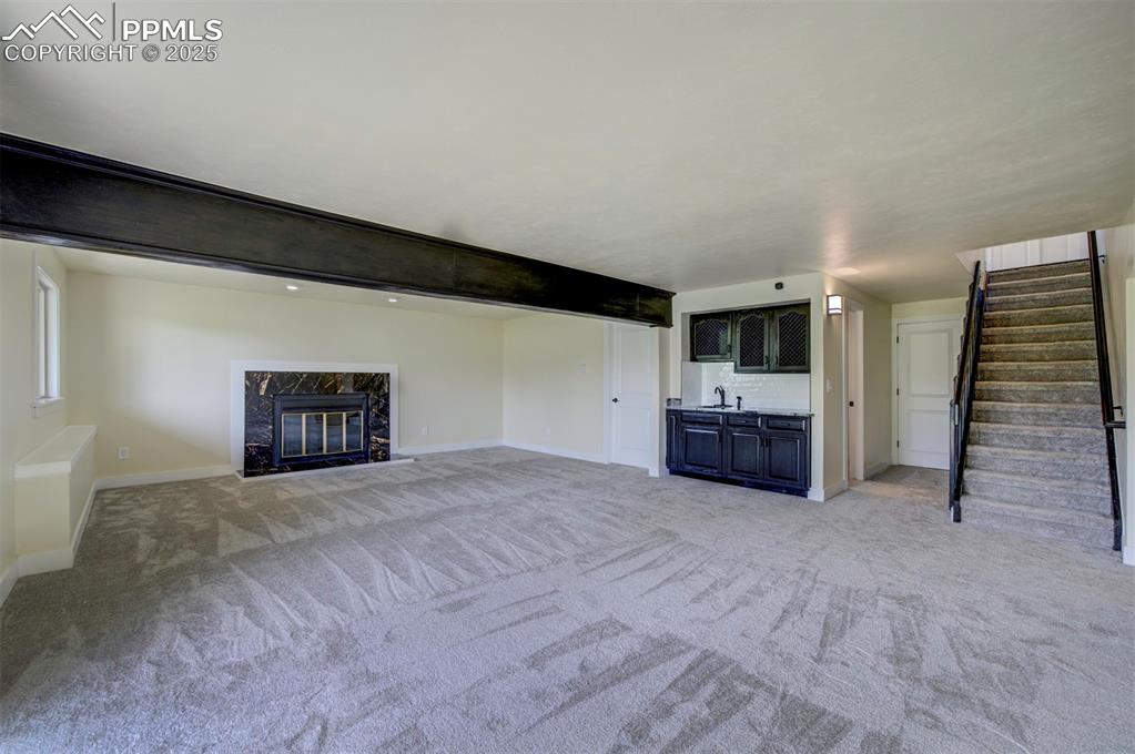 Image 38 of 50: Finished basement with wet bar and fireplace