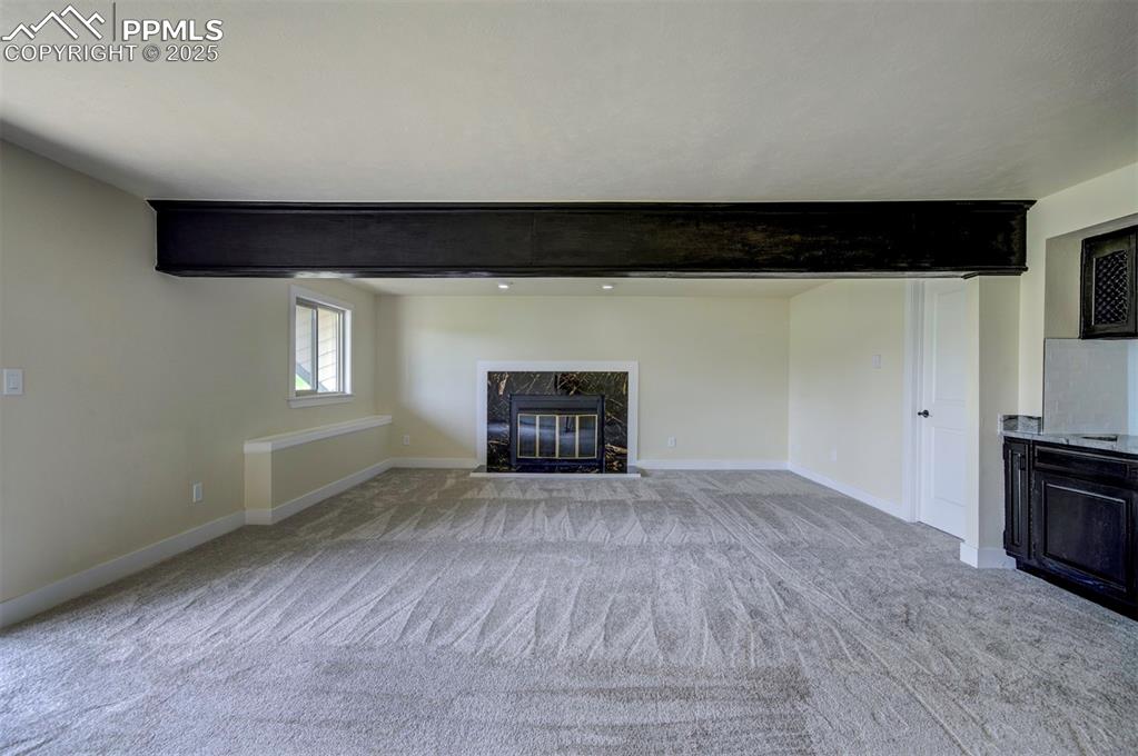 Image 42 of 50: basement fireplace and new carpet
