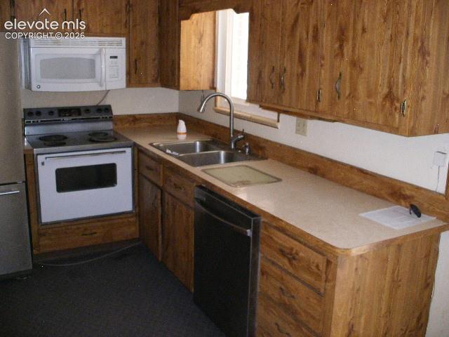 Image 12 of 35: Kitchen featuring wood-finish cabinetry, solid surface countertops, a stain