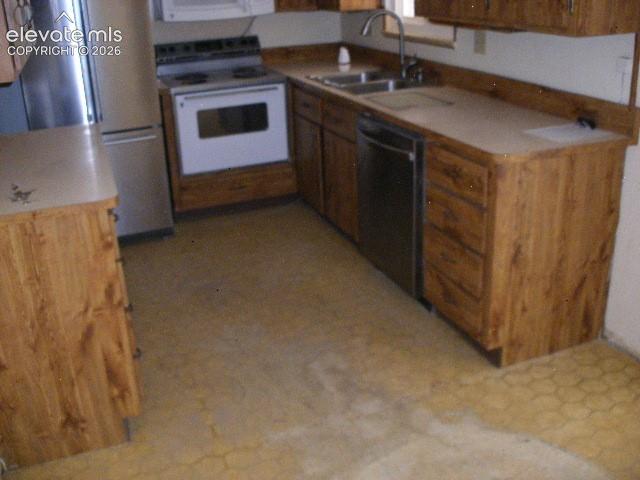 Image 14 of 35: Galley kitchen featuring wood-finish cabinetry, stainless steel refrigerato