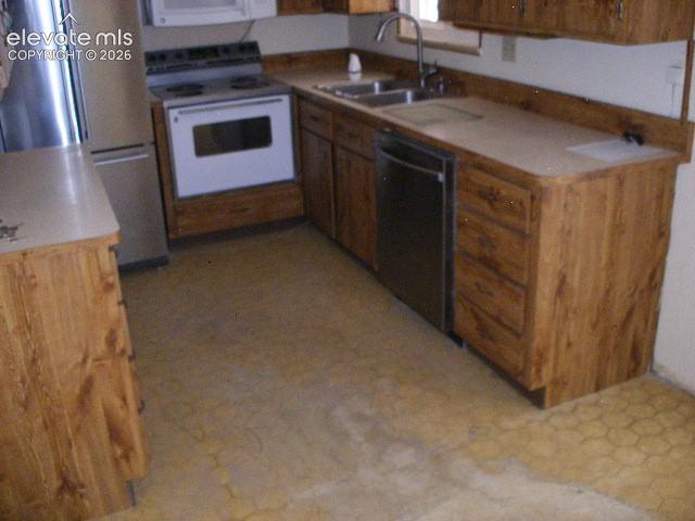 Image 15 of 35: Kitchen featuring wood-finish cabinetry, light-toned countertops, and a dou