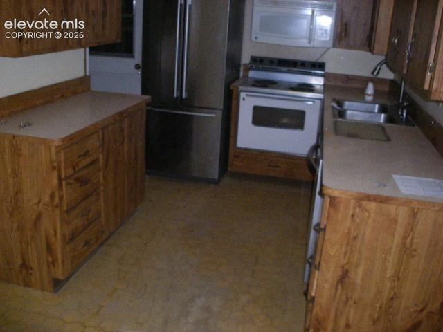Image 17 of 35: Kitchen featuring wood-finish cabinetry, light-toned countertops, a stainle