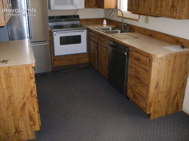Image 18 of 35: Kitchen featuring wood-finish cabinetry, light-toned countertops, and a dou