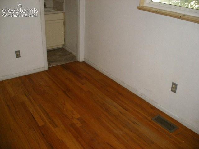 Image 24 of 35: Wood-finish flooring with a natural wood window frame
