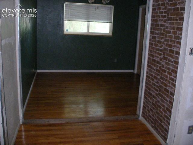 Image 26 of 35: Wood-finish flooring throughout, with a window featuring blinds