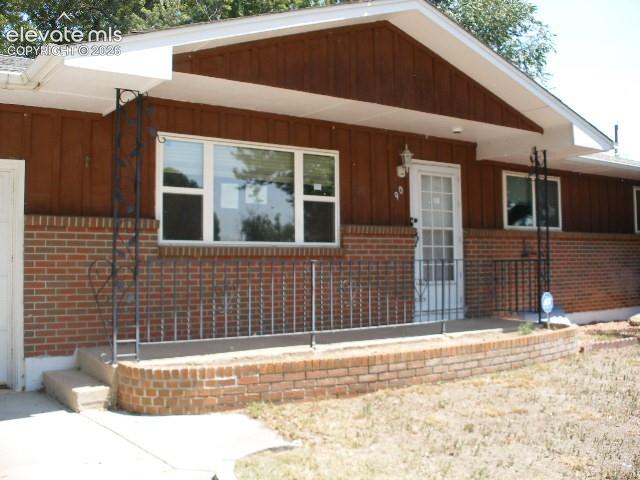 Image 3 of 35: Brick and wood-paneled exterior with a covered entry