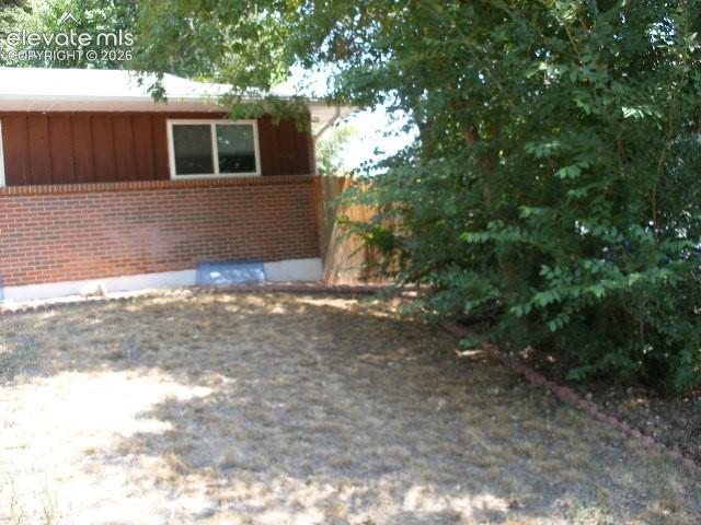 Image 33 of 35: Brick exterior with horizontal siding, white trim, and white-framed window