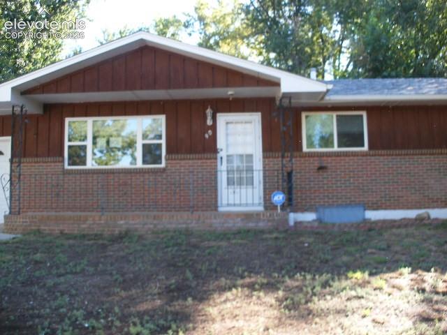 Image 4 of 35: Brick and wood-finish exterior with white trim
