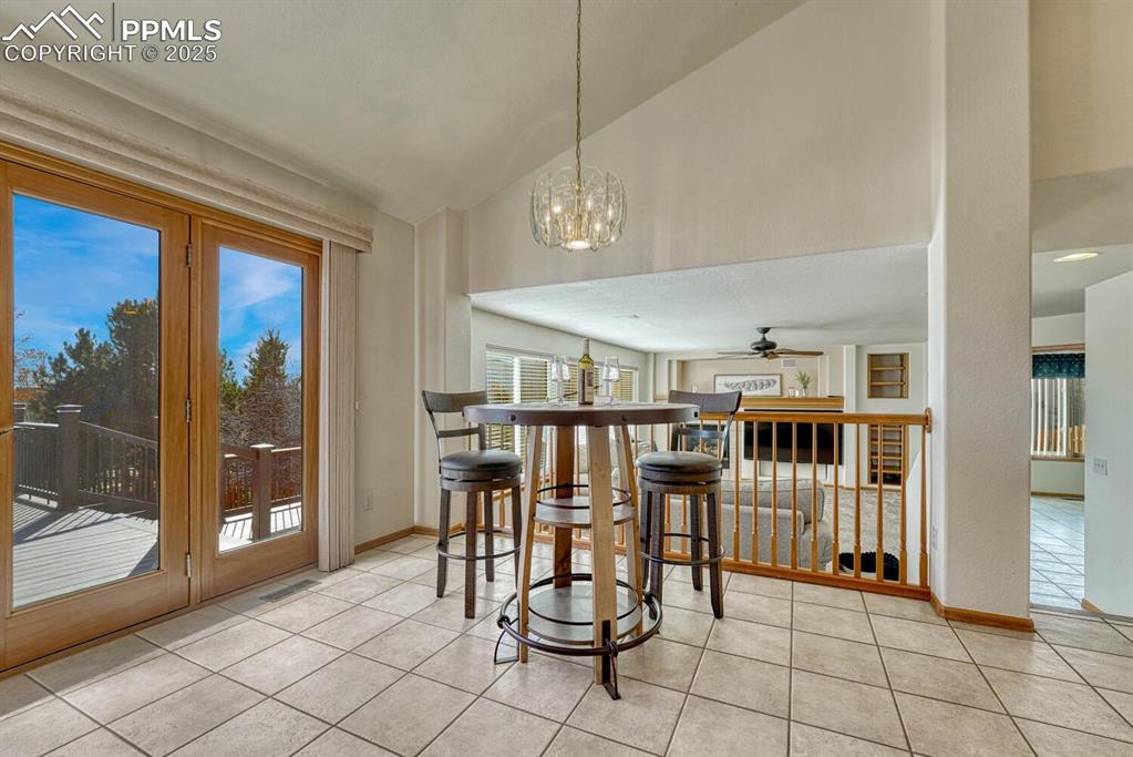 Image 16 of 50: Dining area featuring lofted ceiling, a chandelier, light tile patterned fl